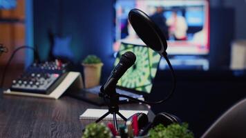 Close up shot of podcast microphone used to record conversations for internet livestreaming show. Streaming sound capturing and recording technology in empty home studio with neon lights video