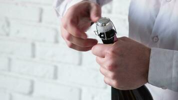 Alkohol Getränke Konzept. Mann Öffnung Flasche von Rose Champagner , Weiß Backstein Mauer Hintergrund video
