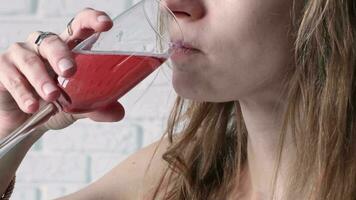 alcohol drinks concept. closeup of woman in cocktail dress drinking rose champagne from glass, white brick wall background video