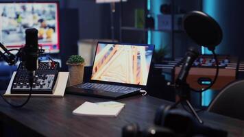 Close up of podcast microphone used to record discussions for online livestreaming channel and 3D animations running on laptop screen. Streaming sound capturing and recording technology video