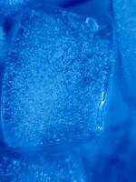 Ice cubes isolated on blue background photo