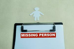 Concept of Missing Person write on paperwork isolated on wooden background. photo