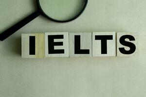 Concept of The wooden Cubes with the word IELTS on wooden background. photo