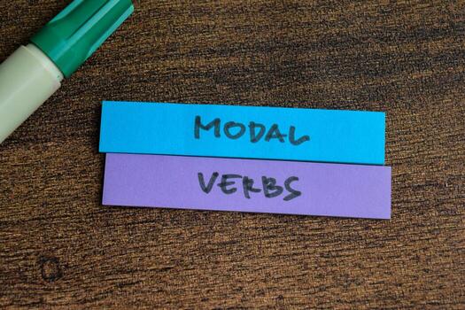 Concept of Modal Verbs write on sticky notes isolated on Wooden Table. photo