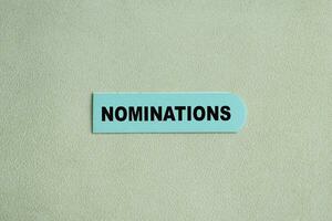 Concept of Nominations write on sticky notes isolated on Wooden Table. photo