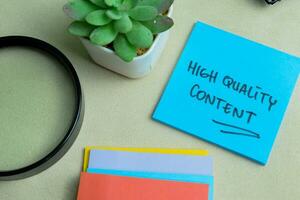 Concept of High Quality Content write on sticky notes isolated on Wooden Table. photo