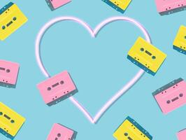 Pattern of retro pink and yellow audio cassette tapes with pink neon heart on blue background. Creative concept of retro technology. 80's aesthetic. Vintage audio cassette tape idea. Retro nostalgia. photo