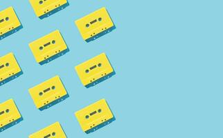 Pattern made with retro yellow audio cassette tapes on light blue background. Creative concept of retro technology. 80's aesthetic. Vintage audio cassette tape pattern idea. Retro nostalgia. Flat lay. photo