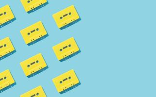 Pattern made with retro yellow audio cassette tapes on light blue background. Creative concept of retro technology. 80's aesthetic. Vintage audio cassette tape pattern idea. Retro nostalgia. Flat lay. photo