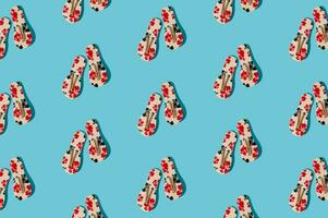 Creative sunlight summer pattern composition made with floral slippers on bright blue background. Minimal summer concept. Trendy summer vacation idea. photo