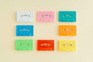 Layout of retro colorful audio cassette tapes on pastel beige background. Creative concept of retro technology. 80's aesthetic. Vintage audio cassette tape idea. Retro nostalgia. Flat lay. Copy space. photo