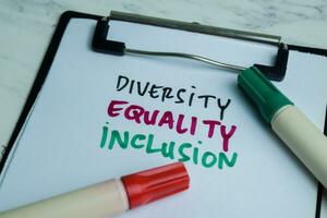 Concept of Diversity Equality Inclusion write on paperwork isolated on wooden background. photo