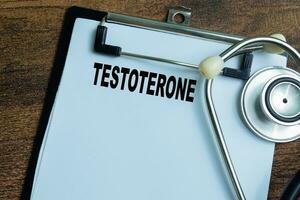 Concept of Testoterone write on paperwork with stethoscope isolated on wooden background. photo
