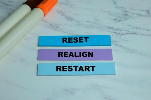 Concept of Reset, Realign, Restart write on sticky notes isolated on Wooden Table. photo