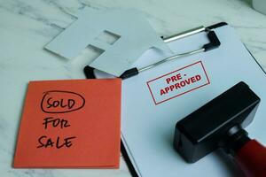 Red Handle Rubber Stamper and Pre-Approved text above paperwork isolated on wooden background photo