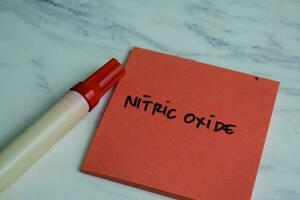 Concept of Nitric Oxide write on sticky notes isolated on Wooden Table. photo