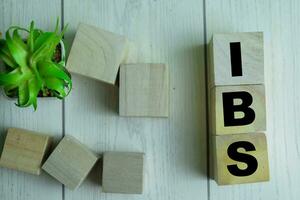 Concept of The wooden Cubes with the word IBS on wooden background.Concept of The wooden Cubes with the word IBS - Irritable Bowel Syndrome on wooden background. photo