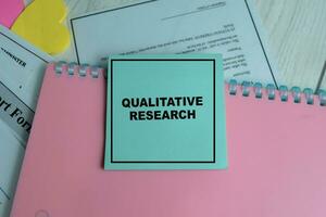 Concept of Qualitative Research write on sticky notes isolated on Wooden Table. photo