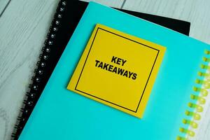 Concept of Key Takeaways write on sticky notes isolated on Wooden Table. photo