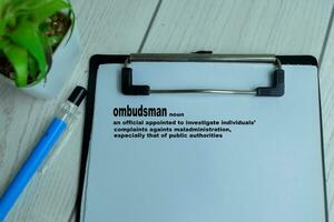 Concept of Definition of Ombudsman write on paperwork with a meaning isolated on wooden background. photo