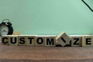 Concept of The wooden Cubes with the word Customize on wooden background. photo