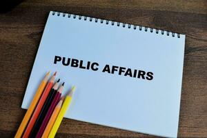 Concept of Public Affairs write on book isolated on Wooden Table. photo