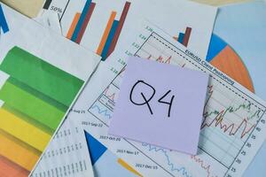 Concept of Q4 - 4th Quarter Period write on sticky notes isolated on Wooden Table. Stock market concept photo