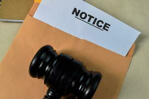 Notice in Brown envelope and judges gavel. Justice and law concept photo
