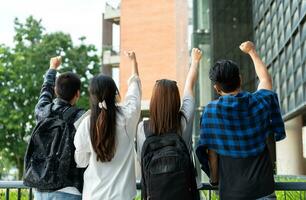 Group of happy young entrepreneurs with hands up and laughing to celebrate and excited success for achievements obtained. Undergraduate students celebrate success after end project, teamwork concept photo