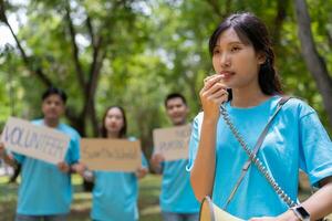 contento joven asiático estudiantes diverso voluntarios sostener un Campaña firmar para limpieza en el parque, el concepto de ambiental conservación en mundo ambiente día, reciclaje, caridad para sostenibilidad. foto