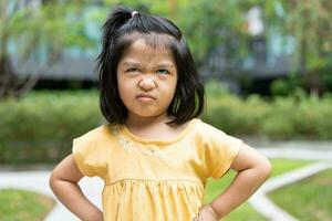 retrato de un asiático enojado y triste pequeño muchacha. el emoción de un niño cuando berrinche y enojado, expresión de gruñón emoción. niño emocional control, atención déficit hiperactividad trastorno concepto tdah foto