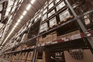 A large warehouse of furniture department stores. A warehouse where goods are stacked in record steel frames for replenishing stock of products sold to customers. photo