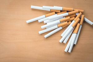 many cigarette on the wooden background photo