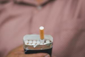 A smoker holding pack of cigarette for giving another people photo