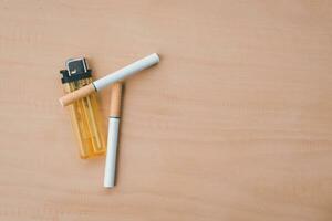 cigarette with lighter on the wood background photo