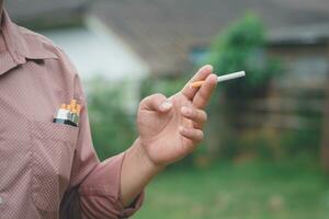 A smoking man is holding cigarette on his hand photo