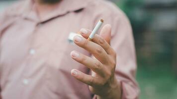 A smoking man is holding cigarette on his hand photo