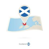 Folded paper map of Scotland with flag pin of Scotland. vector