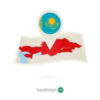 Folded paper map of Kazakhstan with flag pin of Kazakhstan. vector