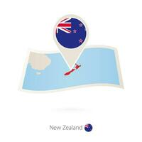 Folded paper map of New Zealand with flag pin of New Zealand. vector