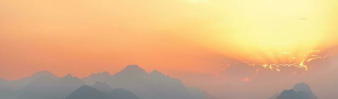 bright sunset or sunrise sky with misty mountains photo