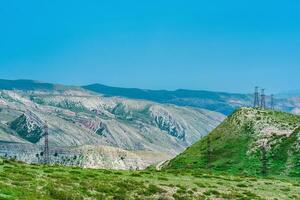 landscape with several power lines in a mountainous area photo