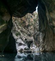 huge stone hangs stuck between two walls of the Goynuk canyon in Turkey photo