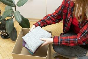 Woman packs clothes in boxes for donating. photo