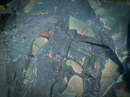 Black stone background. Long black stone texture and textured. Dirty black stone wall. Rock texture with cracks. stone tile floor texture. Old wall texture abstract natural background. photo