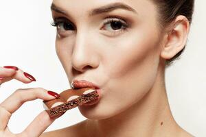 Lovely smiling teenage girl eating chocolate photo