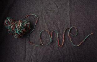 love written of wool yarn on a brown background photo