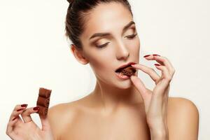 Lovely smiling teenage girl eating chocolate photo