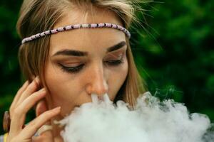 Happy vaping young white blonde girl photo