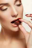 Lovely smiling teenage girl eating chocolate photo